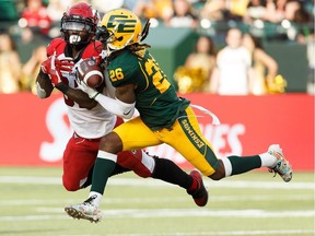 Edmonton Eskimos' Josh Johnson (26) catches an interception on Calgary Stampeders' Josh Huff (83) during the first half of CFL football action at Commonwealth Stadium in Edmonton, on Saturday, Sept. 7, 2019.