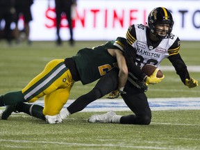 The Edmonton Eskimos' Jordan Hoover (28) tackles the Hamilton Tiger-Cats' Jaelon Acklin (80) during first half CFL action at Commonwealth Stadium, in Edmonton Friday Sept. 20, 2019.