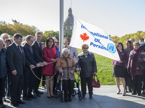 Josephine Pon, Minister of Seniors and Housing and Grant Hunter, Associate Minister of Red Tape Reduction raise a flag on the Legislature grounds for Day of Older Persons in Alberta on October 1, 2019. Photo by