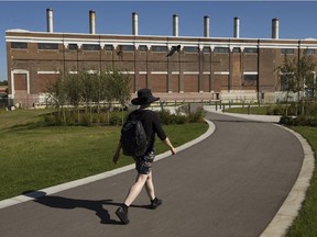 A pedestrian walks past the Rossdale Power Plant in Edmonton on Tuesday, Sept. 3, 2019.