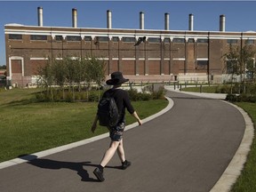 A pedestrian walks past the old power plant in Rossdale on Sept. 3, 2019. The area has been in a long holding pattern for new development.