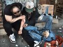Drug addicts inject heroin on the steps of the Washington Hotel in Vancouver's Downtown Eastside in 2017. 