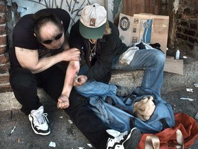 Drug addicts inject heroin on the back steps of the Washington Hotel in Vancouver’s Downtown Eastside in 2017.