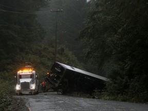 A tow-truck crew removes a bus from an embankment next to a logging road near Bamfield on Vancouver Island on Sept. 14, 2019. Two University of Victoria students died in the Sept. 13 crash.