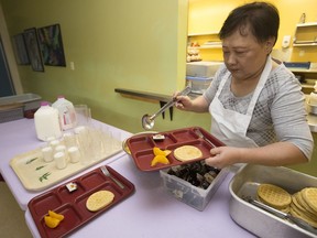 A staff member prepares food as part of St. Teresa of Calcutta School's, 9008 105A Ave., breakfast program, in Edmonton Monday Aug. 14, 2017.
