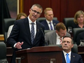 Alberta Finance Minister Travis Toews, left, delivers his budget speech as Premier Jason Kenney listens at the Alberta legislature on Thursday.