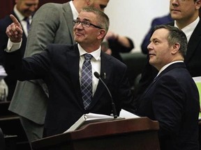 Alberta Finance Minister Travis Toews, left, speaks with Alberta Premier Jason Kenney after Toews delivered his budget speech at the Alberta legislature in Edmonton on Thursday.