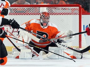 Through a maze of sticks, Carter Hart #79 of the Philadelphia Flyers keeps his eyes on the puck during the second period against the New Jersey Devils at the Wells Fargo Center on Oct. 9, 2019 in Philadelphia, Pennsylvania.