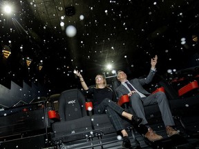 Sarah Van Lange, executive director of communications for Cineplex and Scott Whetham, executive director of operations for Cineplex in Alberta, are surrounded by falling snow as they pose for a photo in the new 4DX Auditorium at Scotiabank Theatre in West Edmonton Mall, Wednesday Oct. 23, 2019. The snow is actually a soap bubble mixture. The new 4DX auditorium provides moviegoers with an immersive, multi-sensory experience, allowing the audience to connect with movies through motion, vibration, wind, snow, lightning, scents, and other special effects that enhance the visuals on screen.
