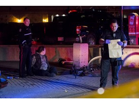 A man sits in handcuffs as police investigate the scene after one person was stabbed in the wake of a death metal concert at the Edmonton Convention Centre on Monday, Sept. 30, 2019.