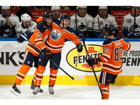 Edmonton Oilers' Connor McDavid (97) celebrates his goal with Darnell Nurse (25) and Matt Benning (83) on Vancouver Canucks' goaltender Jacob Markstrom (25) during third period NHL action at Rogers Place in Edmonton, on Wednesday, Oct. 2, 2019.