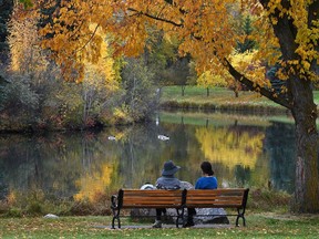 A still autumn morning as two people enjoy the scenery before the city drops 20 degrees in temperature by Tuesday morning, at Hawrelak Park in Edmonton, October 7, 2019.