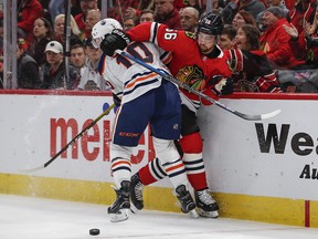 Oct 14, 2019; Chicago, IL, USA; Chicago Blackhawks defenseman Erik Gustafsson (56) battles for the puck against Edmonton Oilers left wing Joakim Nygard (10) during the first period at United Center. Mandatory Credit: Kamil Krzaczynski-USA TODAY Sports ORG XMIT: USATSI-405077