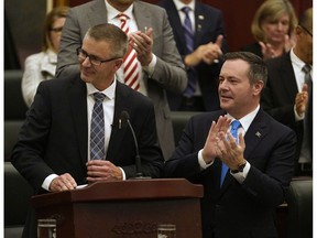 Alberta Finance Minister Travis Toews (left) is applauded by Alberta Premier Jason Kenney (right) after Toews delivered his budget speech at the Alberta Legislature in Edmonton on Thursday October 24, 2019.