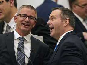 Alberta Finance Minister Travis Toews (left) speaks with Alberta Premier Jason Kenney (right) after Toews delivered his budget speech at the Alberta Legislature in Edmonton on Thursday October 24, 2019.