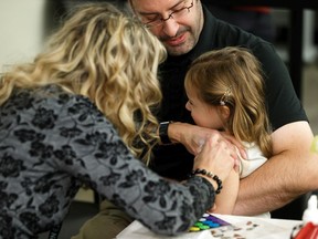 Lizzie Sikora, 3, gets her influenza immunization shot in the arms of her father, Dr. Chris Sikora, Medical Officer of Health for the Edmonton Zone of Alberta Health Services, during a press event at East Edmonton Health Centre in Edmonton, on Monday, Oct. 28, 2019.