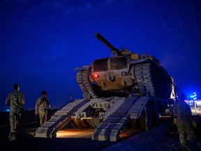 A Turkish army's tank drives down from a truck as Turkish armed forces drive towards the border with Syria near Akcakale in Sanliurfa province on October 8, 2019. - Turkey said on October 8, 2019, it was ready for an offensive into northern Syria, while President Donald Trump insisted the United States had not abandoned its Kurdish allies who would be targeted in the assault. Trump has blown hot and cold since a surprise announcement two days before that Washington was pulling back 50 to 100 "special operators" from Syria's northern frontier. (Photo by BULENT KILIC / AFP)