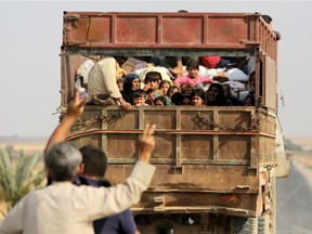 Kurdish Syrian civilians flee the town of Kobane on the Turkish border on Oct.16, 2019 as Turkey and its allies continue their assault on Kurdish-held border towns in northeastern Syria.