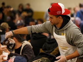 Eskimos wide receiver Anthony Parker serves coffee as the Edmonton Eskimos team with Hope Mission to serve Thanksgiving dinner in Edmonton, on Friday, Oct. 11, 2019. Photo by Ian Kucerak/Postmedia