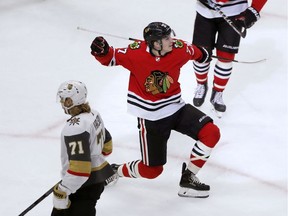 Chicago Blackhawks' Kirby Dach (77) celebrates his first NHL goal as Vegas Golden Knights' William Karlsson (71) skates by during the first period of a hockey game Tuesday, Oct. 22, 2019, in Chicago.