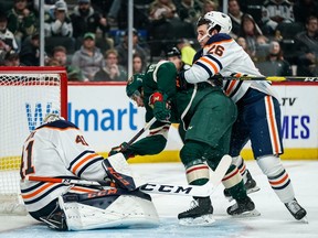 Oct 22, 2019; Saint Paul, MN, USA; Edmonton Oilers goalie Mike Smith (41) makes a save as defenseman Brandon Manning (26) hits Minnesota Wild forward Luke Kunin (19) during the second period at Xcel Energy Center. Mandatory Credit: Brace Hemmelgarn-USA TODAY Sports ORG XMIT: USATSI-405132