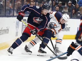 CP-Web. Columbus Blue Jackets' Zach Werenski, left, and Edmonton Oilers' Ryan Nugent-Hopkins fight for a loose puck during the first period of an NHL hockey game Wednesday, Oct. 30, 2019, in Columbus, Ohio.