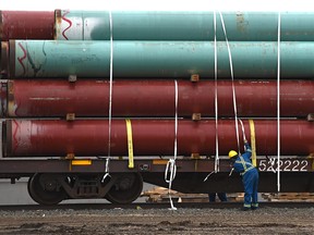 Workers securing pipes to a flatbed railcar along the tracks that run parallel to Gateway Blvd. in Edmonton, October 15, 2019. Ed Kaiser/Postmedia