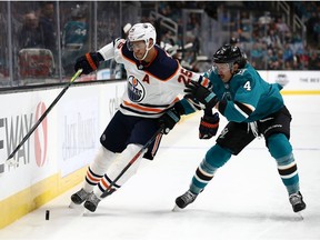 Brenden Dillon of the San Jose Sharks, right, tries to get the puck from Darnell Nurse of the Edmonton Oilers at SAP Center on November 12, 2019 in San Jose, Calif.