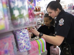 Cst. Michelle Patenaude helps Elizabet Hailu shop for Christmas presents during the annual CopShop at Londonderry Mall, in Edmonton Wednesday Dec. 4, 2019. Members of the Edmonton Police Service partnered with 26 children from northeast community schools to help them purchase Christmas gifts for themselves and their family. Photo by David Bloom