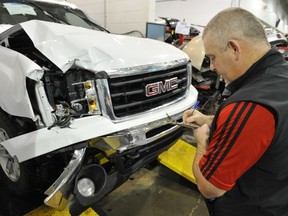Repair planner Gary Ferguson writes an estimate to front end damage to a pickup at Herbers on Parsons Road.