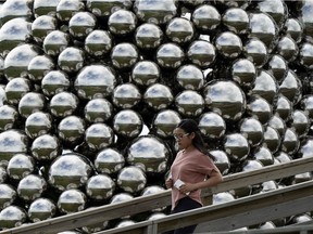 Shuang Chen runs down the staircase beside the Talus Dome public art installation on Whitemud Drive in Edmonton on Friday Sept. 6, 2019.