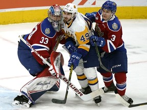 Saskatoon Blades Jerzy Orchard (middle) is squeezed in between Edmonton Oil Kings goalie Sebastian Cossa (left) and Jacson Alexander (right) during WHL hockey game action in Edmonton on Friday November 1, 2019.