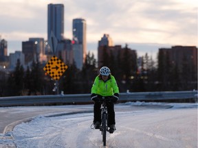 A cyclist negotiates icy streets at Ada Boulevard and 75 Street as the sun sets on a cold evening in Edmonton, on Tuesday, Nov. 5, 2019. Cold winter like weather has settled into the capital region for the next few days.