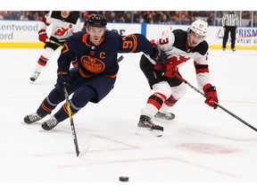 Edmonton Oilers' Connor McDavid (97) battles New Jersey Devils' Nico Hischier (13) at Rogers Place in Edmonton, on Friday, Nov. 8, 2019.