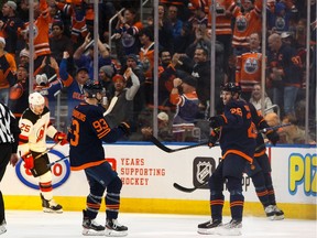 Edmonton Oilers' Leon Draisaitl (29) celebrates a goal with teammates on New Jersey Devils' goaltender Cory Schneider (35) during the second period of a NHL hockey game at Rogers Place in Edmonton, on Friday, Nov. 8, 2019.