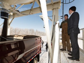 Farm worker Dylan House (left)) speaks with Agriculture and Forestry Minister Devin Dreeshen while filling a grain semi on the Farm Freedom and Safety Act on the Mulligan Farm in Sturgeon County outside of Edmonton, on Wednesday, Nov. 20, 2019.