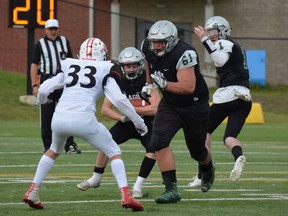 Austin O'Brien Crusaders High School offensive lineman Evan Balaban (61) leads the way for running back Carson Eddy (6) after taking a handoff from quarterback Sam Kolkman (1) in a game earlier this year. The Crusaders face Holy Trinity Academy of Okotoks in the Alberta Tier 2 provincial final in Raymond, Alta., on Friday, Nov. 22, 2019. Supplied/Sheryl Ogonoski, Austin O'Brien High School