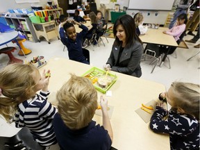 Education Minister Adriana LaGrange serves a snack to students before a news conference at St. Jerome Catholic Elementary School in Edmonton on Thursday, Nov. 28, 2019, where a 20 per cent increase in funding for school nutrition programs was announced.