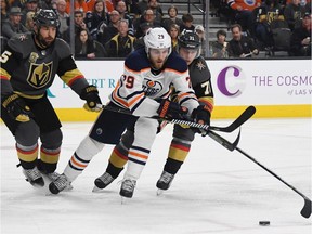 LAS VEGAS, NV - JANUARY 13: (L-R) Deryk Engelland #5 of the Vegas Golden Knights, Leon Draisaitl #29 of the Edmonton Oilers and William Karlsson #71 of the Golden Knights fight for the puck in the third period of their game at T-Mobile Arena on January 13, 2018 in Las Vegas, Nevada. The Oilers won 3-2 in overtime.