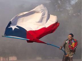 A demonstrator flutters a Chilean national flag during clashes with security forces following a protest against the government of Chilean President Sebastian Pinera in Santiago on November 3, 2019. - Unrest in Chile began on October 18 with protests against a rise in metro ticket prices and other austerity measures that descended into vandalism, looting and clashes between demonstrators and police. Protesters are angry about the cost of living and a yawning gap between rich and poor.