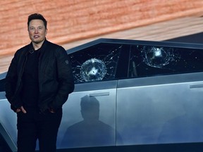 Tesla co-founder and CEO Elon Musk stands in front of the shattered windows of the newly unveiled all-electric battery-powered Tesla's Cybertruck at Tesla Design Center in Hawthorne, California on Nov. 21, 2019.
