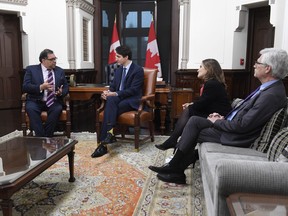 Deputy Prime Minister Chrystia Freeland and Jim Carr, right, look on as Prime Minister Justin Trudeau speaks with Calgary Mayor Naheed Nenshi in his office on Parliament Hill in Ottawa, Thursday Nov. 21, 2019.