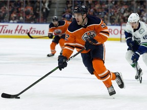 The Edmonton Oilers' Patrick Russell (52) is chased by the Vancouver Canucks' Elias Pettersson (40) in Edmonton on Saturday, Nov. 30, 2019.