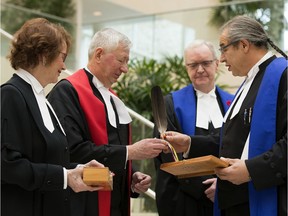 Provincial court Judge Ivan Ladouceur, left, presents Chief Judge Terrence Matchett, Associate Chief Justice Ken Nielsen and Chief Justice Catherine Fraser with eagle feathers during a ceremony on Friday, Nov. 8, 2019, at city hall to mark the introduction of witnesses being allowed to swear oaths upon the a sacred eagle feather in Alberta courtrooms.