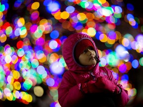 Divya Gurung 4, sits on her father Aditya Gurung's shoulders as they take in the Holiday Light Up event in Churchill Square, in Edmonton Thursday Nov. 14, 2019.