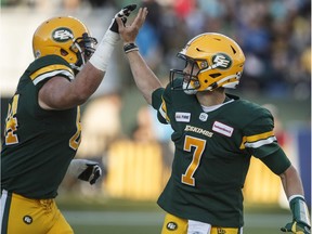 Edmonton Eskimos quarterback Trevor Harris (7) and Tommie Draheim (64) celebrate a touchdown against the Toronto Argonauts during first half CFL action in Edmonton, Alta., on Thursday July 25, 2019.