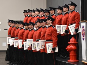 Twenty firefighters from recruit class 151 who have undergone 14 weeks of intense training pose for pictures after receiving their caps and certificates during their graduation ceremony at the Expo Centre in Edmonton on Friday, Nov. 29, 2019.