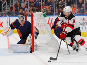 New Jersey Devils star Taylor Hall carries the puck around the Edmonton Oilers net, guarded by goalie Mikko Koskinen, during NHL action on Nov. 8, 2019, at Rogers Place.