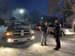 Const. David Castillo (right) speaks to King Edward Park resident Dennis Beer Wednesday morning about the increase of stolen vehicles left idling in the city. Nearly 250 idling vehicles have been stolen to date in 2019. Photo Moira Wyton/Postmedia