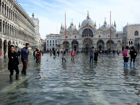 Tourists walk in St. Mark's Square after days of severe flooding in Venice, Italy, November 16, 2019. REUTERS/Manuel Silvestri